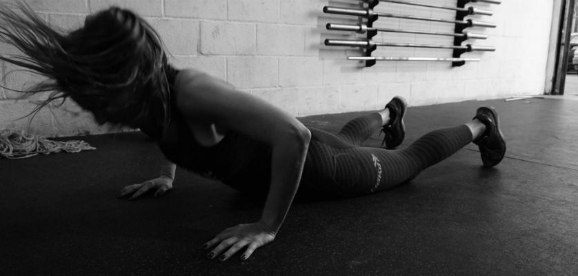 Test burpee hecho por una chica fitness en un gimnasio